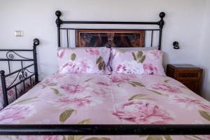 a bedroom with a bed with pink flowers on it at C'era Una Volta B&B in Perugia +99 photos