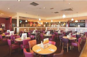 a restaurant with tables and chairs and a bar at Lifes a Beach on Presthaven Sands in Prestatyn