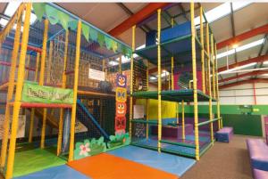 an indoor play area with a slide and swings at Lifes a Beach on Presthaven Sands in Prestatyn