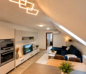 a living room with a blue couch and a tv at Elysian apartment 1 in Trenčín