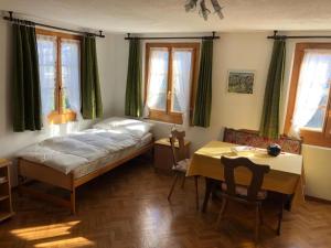 a bedroom with a bed and a table and windows at Apartment Panoramablick mit Charme by Interhome in Wasen