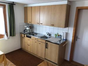 a kitchen with wooden cabinets and a sink at Apartment Panoramablick mit Charme by Interhome in Wasen