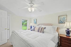 a bedroom with a white bed with a ceiling fan at Chic Sky Valley Resort Home on Golf Course! in Sky Valley