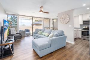 a living room with a couch and a clock on the wall at 103 Kihei Holiday in Kihei