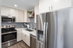 a kitchen with a stainless steel refrigerator and white cabinets at 103 Kihei Holiday in Kihei