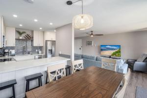 a kitchen and living room with a wooden table and chairs at 103 Kihei Holiday in Kihei