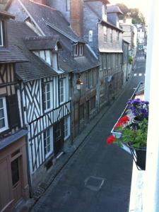 Une rue vide avec des bâtiments et des fleurs dans une fenêtre dans l'établissement Au Bois Normand, à Honfleur