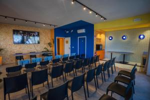 a room with chairs and tables and a blue wall at Fantini Club Hotel in Cervia