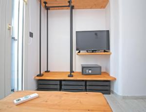 a room with a tv and a table with a remote control at Camara Studio Mykonos in Ornos