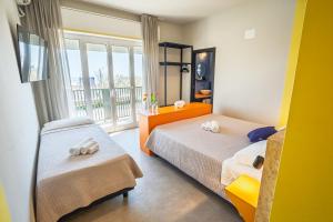 a bedroom with two beds and a window at Fantini Club Hotel in Cervia +98 photos