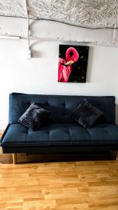 a black couch in a room with a picture on the wall at Apartamento Barranquero Centro in Quimbaya