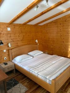 a bed in a room with wooden walls at Apartments Grbović in Žabljak