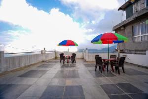 two tables and chairs with umbrellas on a roof at Dixit Homestaay & Hostel in Darjeeling