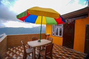 a table with a colorful umbrella on a balcony at Dixit Homestaay & Hostel in Darjeeling