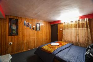a bedroom with wooden walls and a bed with two towels on it at Dixit Homestaay & Hostel in Darjeeling
