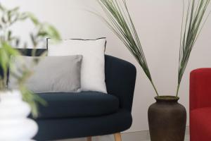 a blue chair with a pillow and a vase at Jacuzzi Penthouse with Large Terrace & Views in Marsalforn +21 photos