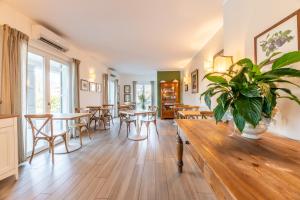 a living room with tables and chairs and a potted plant at Foresteria Villa Margherita in Colico
