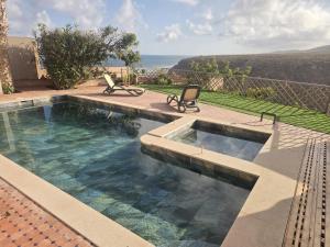 a swimming pool with two chairs sitting next to it at Ocean View 6 bed Villa and Pool in Mirleft