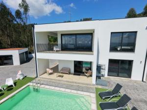a house with a swimming pool in front of it at Villa Paioryna - Moradia num local tranquilo in Vila Verde