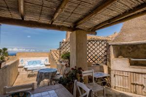 a patio with a table and chairs on a balcony at GuestHost - Sea View Flat with Veranda and Pool in Liscia di Vacca