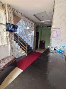 a room with a staircase and a red carpet at Hotel Relax Inn in Madikeri +6 photos