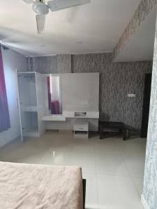 a room with a bed and a mirror on the wall at Hotel Relax Inn in Madikeri