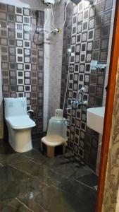 a bathroom with a toilet and a sink at Hotel Relax Inn in Madikeri