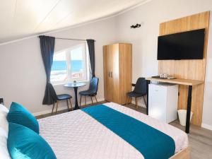 a bedroom with a bed and a television and a table at Paradise View Rooms in Shkorpilovtsi