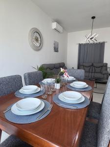 a dining room table with plates and silverware on it at Casa moderna, 3 recámaras, alberca, La Paz BCS in La Paz +14 photos