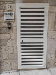 a white garage door on a stone wall at Corollario 21 in Barletta