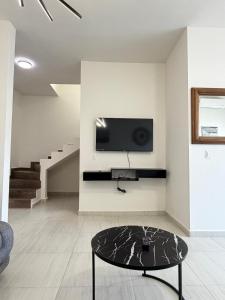 a living room with a tv and a coffee table at Casa moderna, 3 recámaras, alberca, La Paz BCS in La Paz