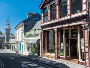 a row of shops on a city street with a clock tower at 1 Bed in Bucknell oc-94662 in Letton