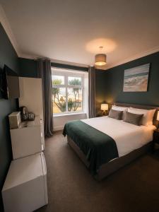 a bedroom with a large bed and a window at The Lyncroft in Newquay