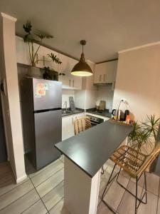 a kitchen with a refrigerator and a table and chairs at Exponor 2026 DEPARTAMENTO 1 DORMITORIO in Antofagasta