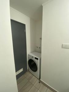 a laundry room with a washing machine and a door at Exponor 2026 DEPARTAMENTO 1 DORMITORIO in Antofagasta