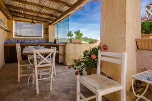 a patio with a table and chairs and a counter at GuestHost - Sea View Flat with Veranda and Pool in Liscia di Vacca