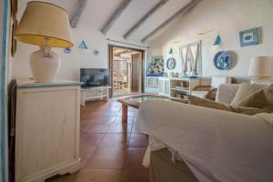a living room with a couch and a table at GuestHost - Sea View Flat with Veranda and Pool in Liscia di Vacca