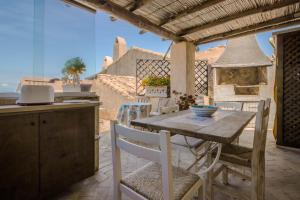 a kitchen and dining room with a table and chairs at GuestHost - Sea View Flat with Veranda and Pool in Liscia di Vacca