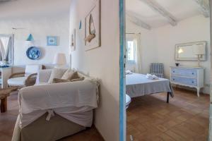 a white bedroom with a bed and a couch at GuestHost - Sea View Flat with Veranda and Pool in Liscia di Vacca +35 photos