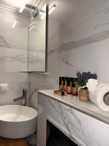 a white bathroom with a sink and a tub at Pinelopi’s House in Porto Koufo