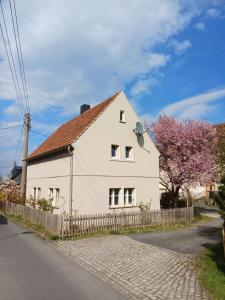 a white house with a fence and a tree at Hirschhäusl in Großschönau