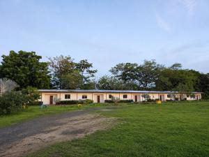 a large building with a field in front of it at HOTEL y RESTAURANTE RANCHO GRANDE in Cicuco