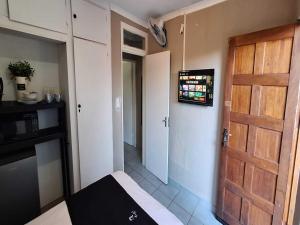 a room with a door and a kitchen with a refrigerator at Jukskei Big5 - Rhino in Fourways