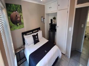 a bedroom with a bed and a picture of a cow at Jukskei Big5 - Rhino in Fourways