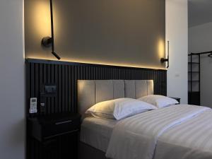 a bedroom with a large bed with white sheets and pillows at Lumen - Bright Stay in Bucharest in Bucharest