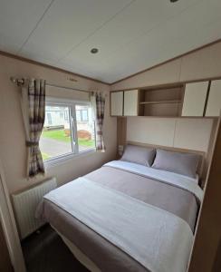 a bedroom with a large bed and a window at The Cavern Retreat in Rhyl +18 photos