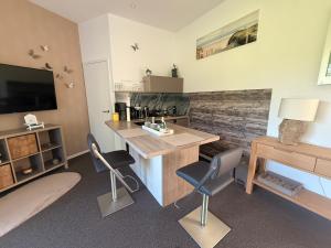a room with a desk and chairs and a television at das Ferienhaus Auszeit in Kranenburg