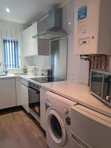 a white kitchen with a washing machine in it at Waterloo apartment in Middlesbrough