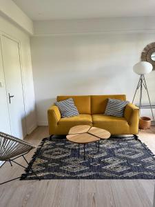 a living room with a yellow couch and a rug at chambre avec terrasse et coin repas in Ciboure