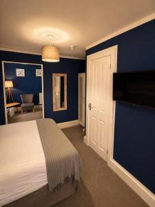 a bedroom with a bed and a blue wall at The Lyncroft in Newquay
